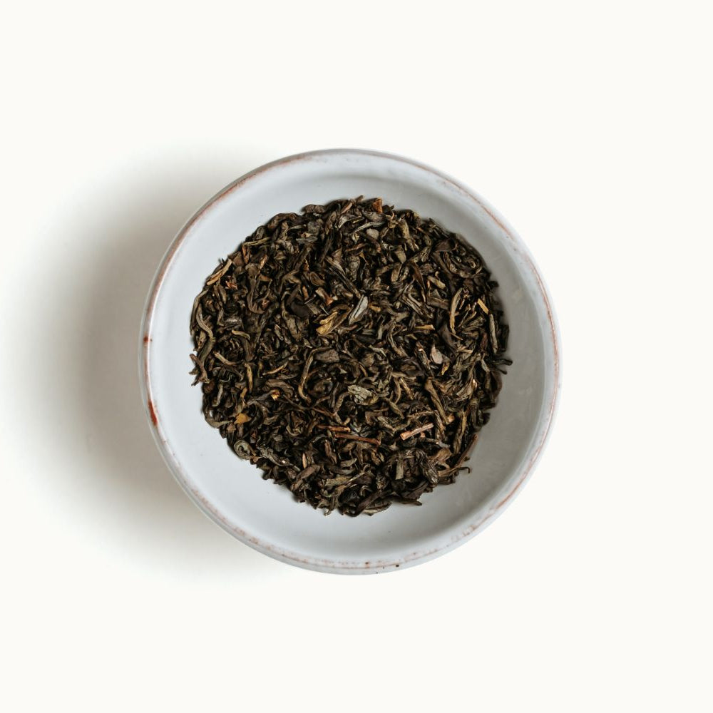 
                  
                    Jasmine green tea leaves in a white bowl on a white background
                  
                